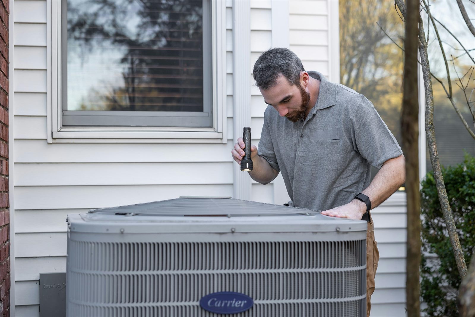 HVAC technician inspecting a home air conditioner in Columbus Ohio